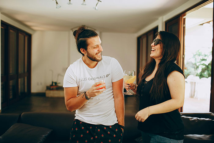 Young couple enjoying drinks indoors, illustrating togetherness and social interaction.