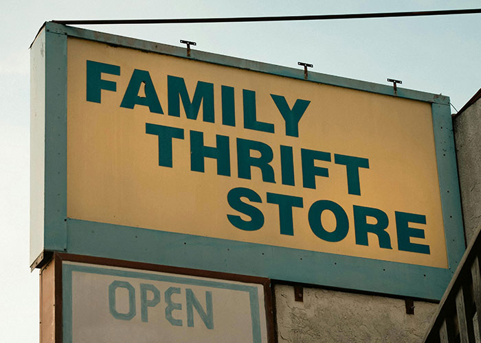 Yellow "Family Thrift Store" sign, symbolizing small town secrets.