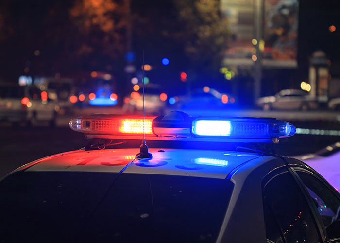 Police car with flashing lights at night, representing a small town incident.