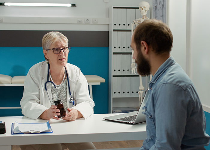Doctor discussing with patient in a clinic room, symbolizing small town incident narratives.