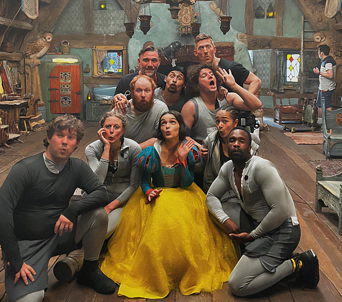 Cast of Disney's Snow White poses playfully on set, highlighting its flop status and humor. Cast of Disney's Snow White poses playfully on set, highlighting its flop status and humor.