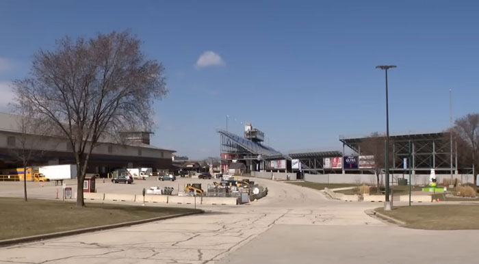 Industrial area with stadium and parked construction equipment under a clear blue sky, no visible people. Industrial area with stadium and parked construction equipment under a clear blue sky, no visible people.
