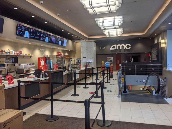 AMC movie theater lobby with empty concession stands and queue area.