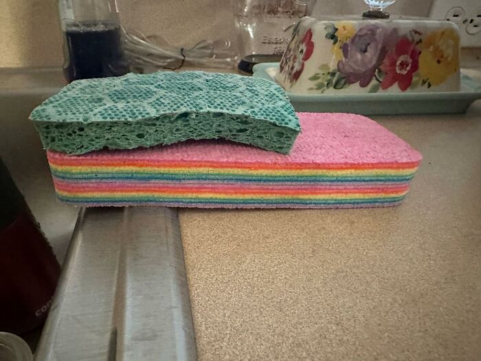 Colorful sponges stacked on a kitchen counter, a tool for unexpected cleaning tasks.
