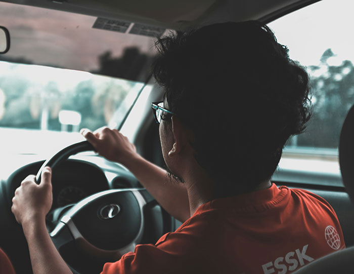 Hombre conduciendo un coche concentrado, simbolizando a personas que aún siguen vivas gracias a decisiones espontáneas.