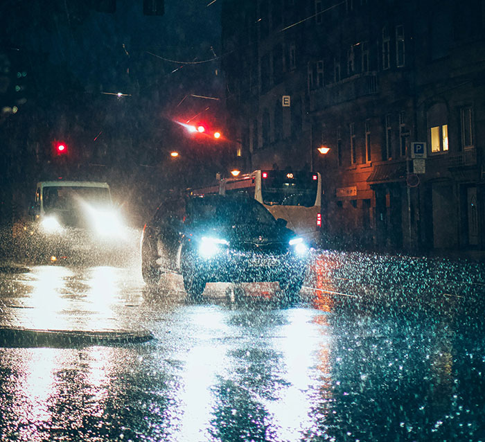 Car and bus in rainy night traffic, highlighting split-second decisions in risky conditions.