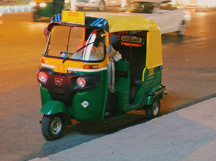 Mototaxi verde y amarillo detenido en la calle, imagen relacionada con personas que sobreviven por decisiones espontáneas.