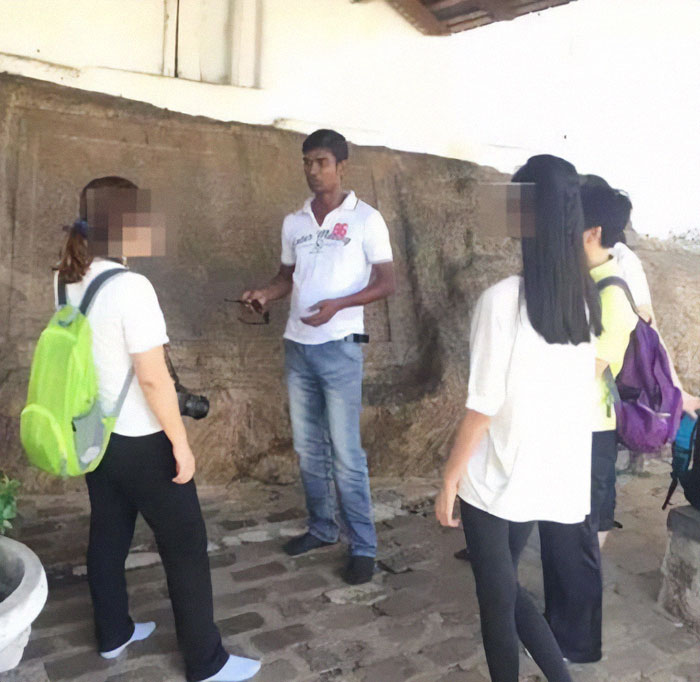 Tourist group receives guidance near a stone wall, emphasizing travel common sense. Tourist group receives guidance near a stone wall, emphasizing travel common sense.