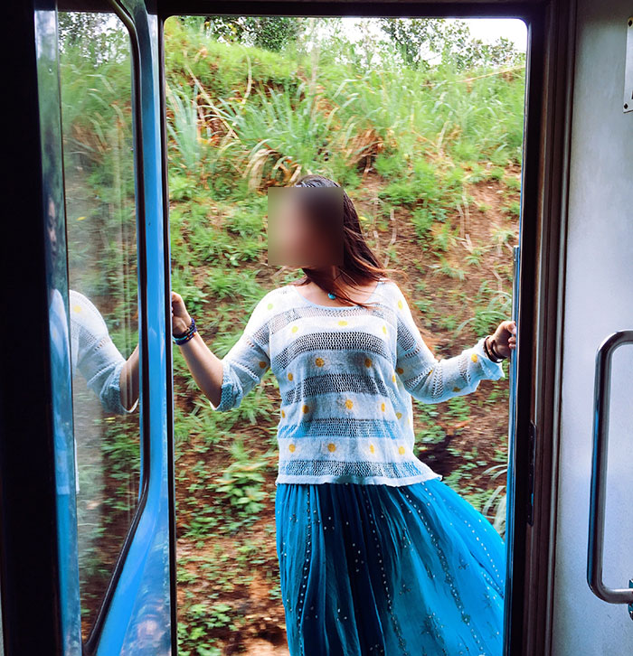 Tourist leaning out of moving train for photo, greenery in the background. Tourist leaning out of moving train for photo, greenery in the background.