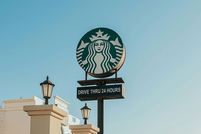 Starbucks drive-thru sign under clear sky, linked to customer burns lawsuit.