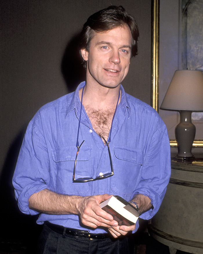 Man in blue shirt holding a book, living situation explored in scandal documentary.