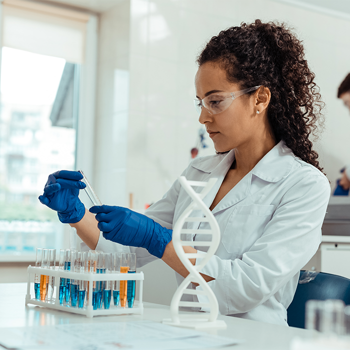 Scientist holding a tube indoors. Scientist holding a tube indoors.