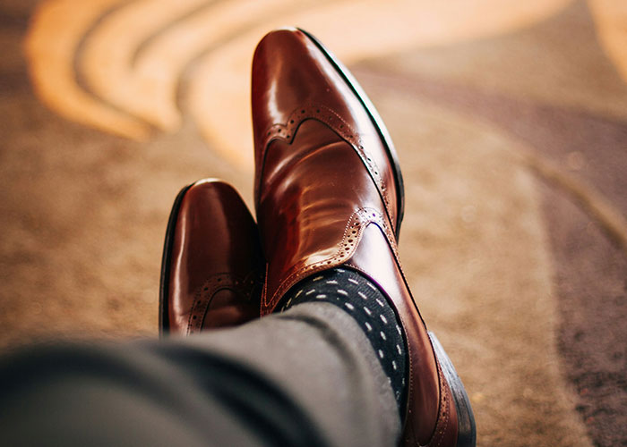 Polished brown shoes resting on carpet, an unexpected sight at the gym.