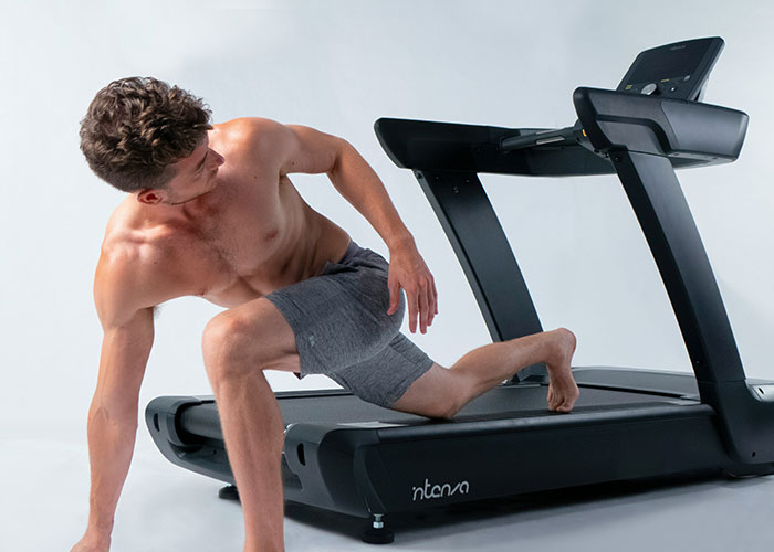 Man doing unusual stretch on a treadmill, showcasing bizarre gym behavior.
