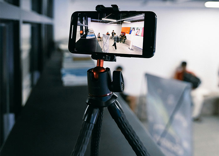 Smartphone on tripod recording unusual gym activity.
