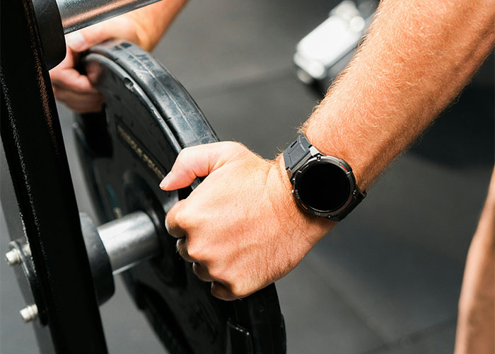 Hands adjusting gym equipment weight.