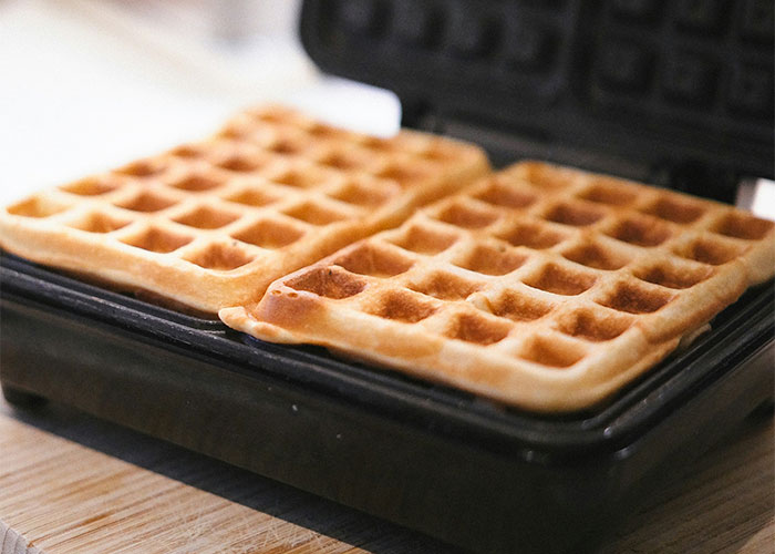 Waffles cooking in a waffle maker, related to wild reasons for lawsuits.