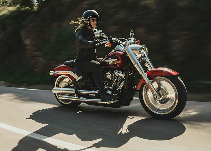 Person on a red motorcycle riding on a road, highlighting a reason for a wild lawsuit.