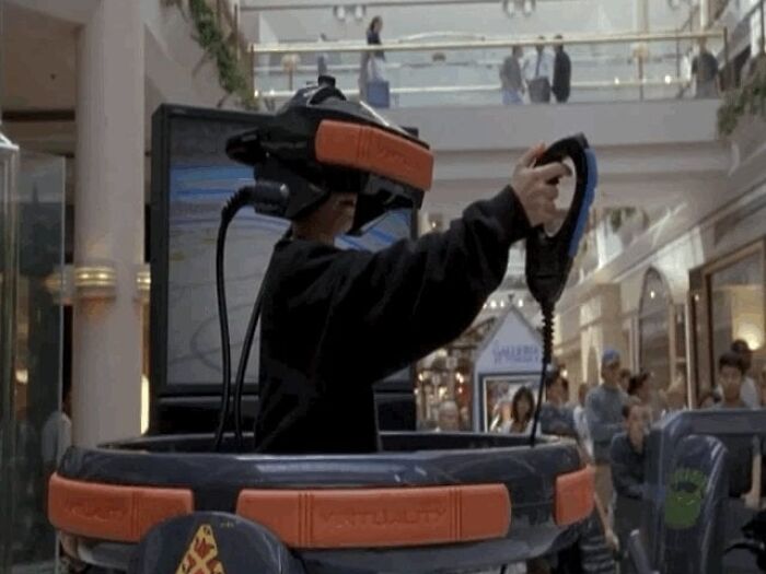 Person using a nostalgic discontinued VR gaming machine in a mall setting.