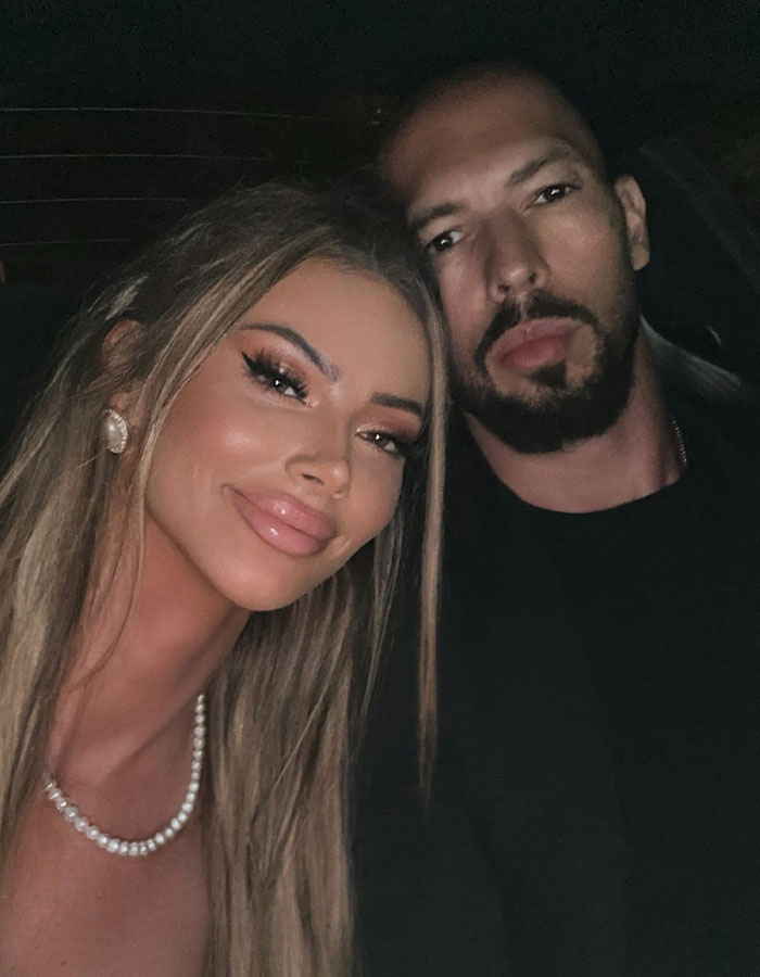 Two people posing closely in a dimly lit setting, connected to a discussion about Andrew Tate's lawyer. Two people posing closely in a dimly lit setting, connected to a discussion about Andrew Tate's lawyer.