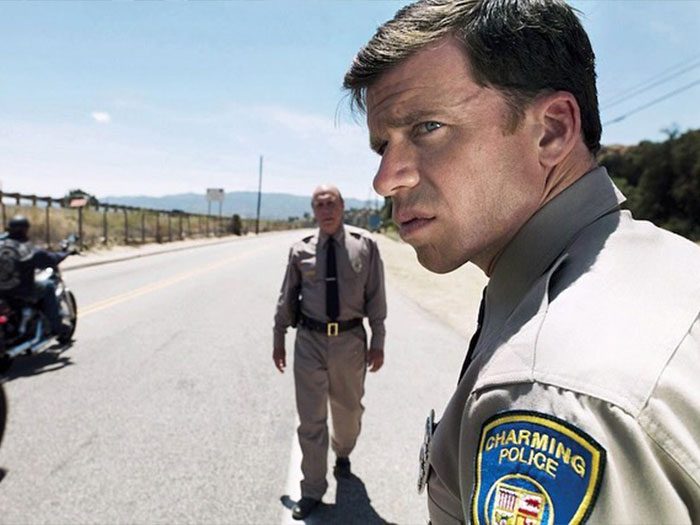 Police officers on road, focused expressions, related to Yellowstone spin-offs.