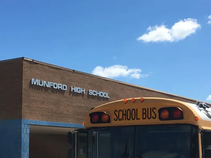 School bus parked outside Munford High School on a sunny day with clear blue sky. School bus parked outside Munford High School on a sunny day with clear blue sky.