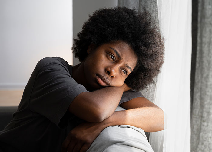 Teen looking worried, resting head on arms near a window, discoveries involving a hidden camera on her mind. Teen looking worried, resting head on arms near a window, discoveries involving a hidden camera on her mind.