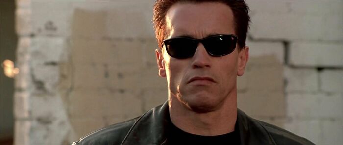 Actor in leather jacket and sunglasses, embodying a role perfectly suited for them.