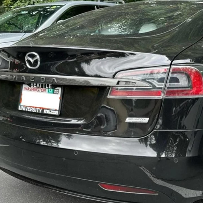 Tesla owner changes car logo to Mazda amid controversy, aiming to avoid vandalism.