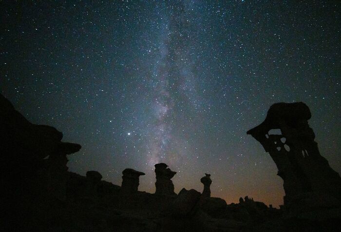 Starry sky with rock formations silhouetted, showcasing a night sky that lives up to expectations.