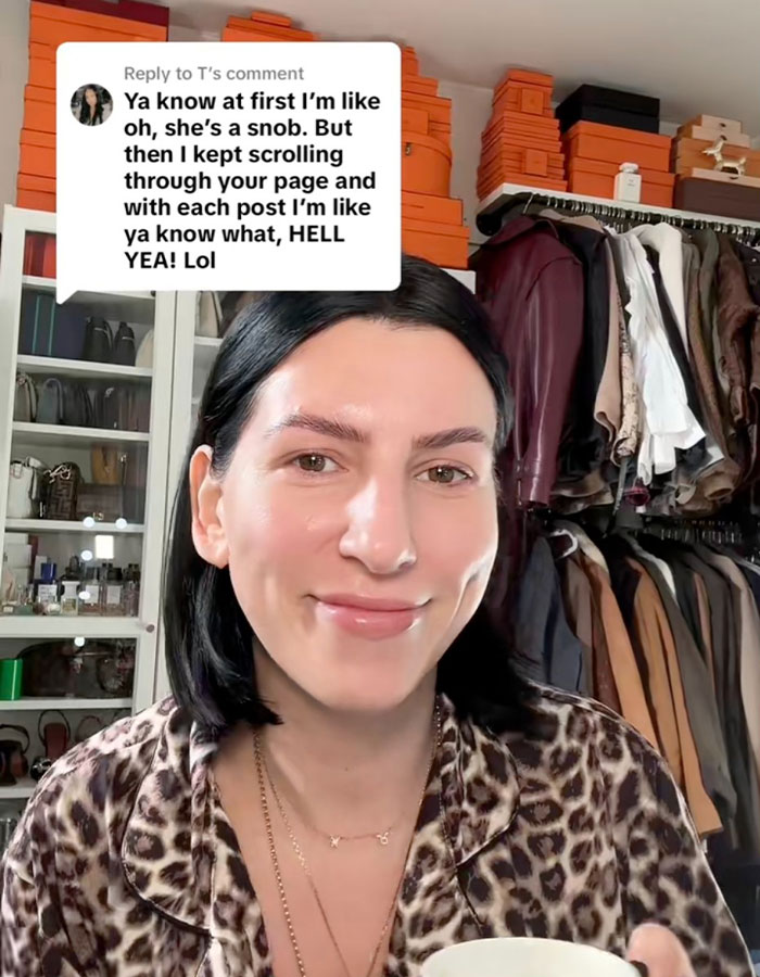 Person in a leopard print shirt holding a cup, smiling in front of a wardrobe. Child-free lifestyle discussion above.
