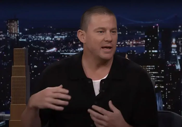 Celebrity discussing wasteful habits on a talk show with a city skyline in the background.