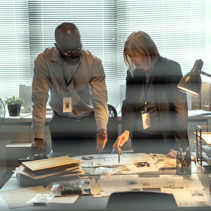 Investigators review documents in a case. Investigators review documents in a case.