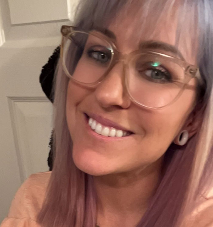 Smiling woman with glasses and light hair in indoor setting. Smiling woman with glasses and light hair in indoor setting.