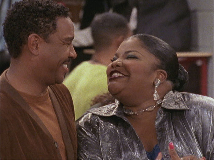 TV couple sharing a laugh at a social gathering, embodying the theme of on-screen chemistry.