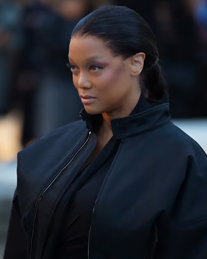 Tyra Banks at Paris Fashion Week, wearing a black outfit with taut skin, draws mixed fan reactions.