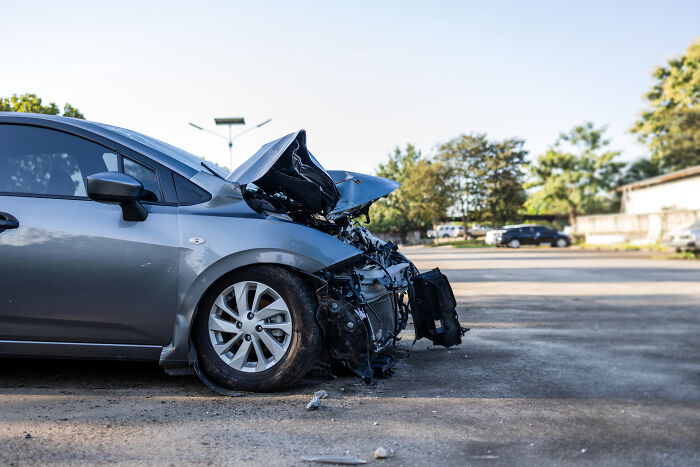 A car with a significantly crumpled front, highlighting unexpected things in reality after a crash.