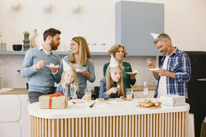 Couple at a party with friends and kids, considering uninviting due to unruly behavior.