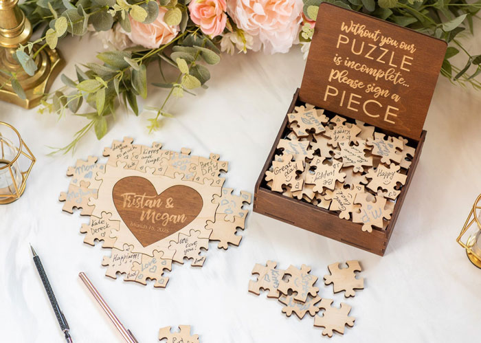 Wedding guest book puzzle with pieces signed by guests, surrounded by flowers. Wedding guest book puzzle with pieces signed by guests, surrounded by flowers.