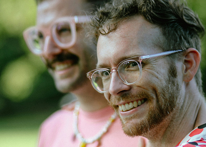 Two smiling men wearing glasses, with one in focus, illustrating influencer and unusual facts.