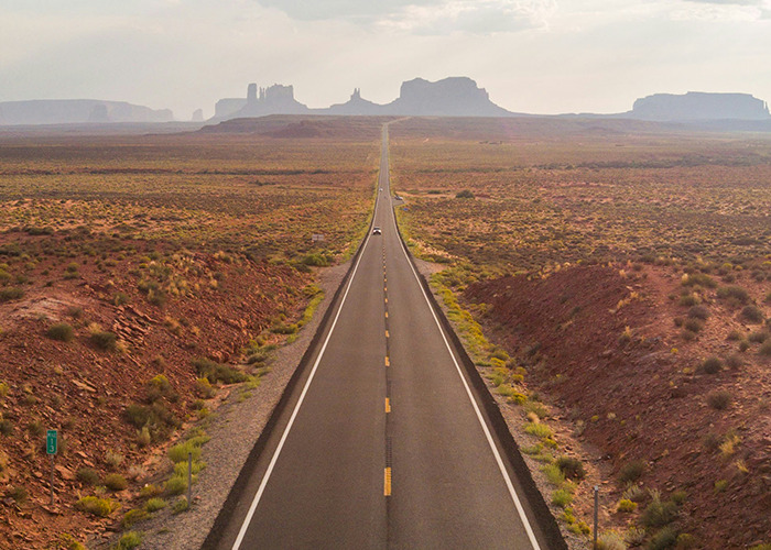 Open road through desert landscape, highlighting vast horizons and serene beauty.