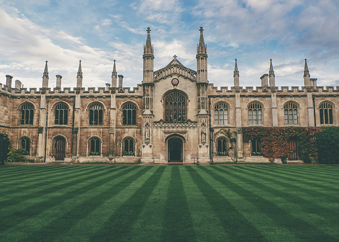 Gothic-style university building with green lawn, cloudy sky; setting for unusual and unsettling facts.