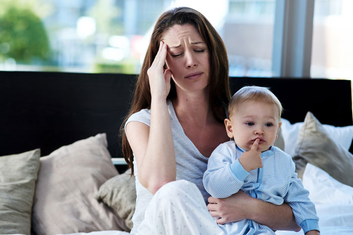 A frustrated mom with her baby, highlighting microwave breast milk issues.