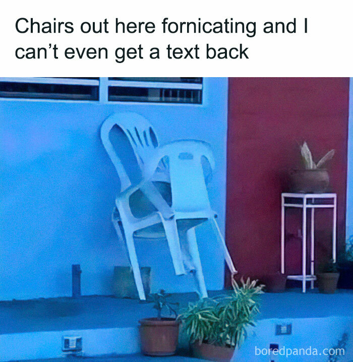 Two plastic chairs stacked humorously outside on a porch, resembling a human pose.