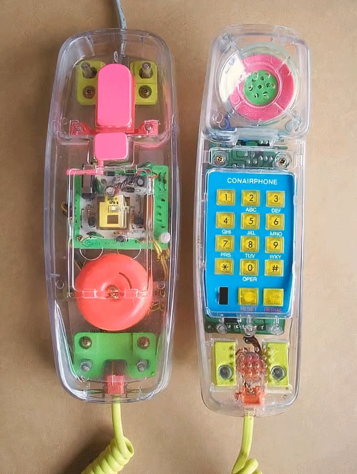Vintage 1980s see-through landline phone with colorful interior components and rotary-style keypad.