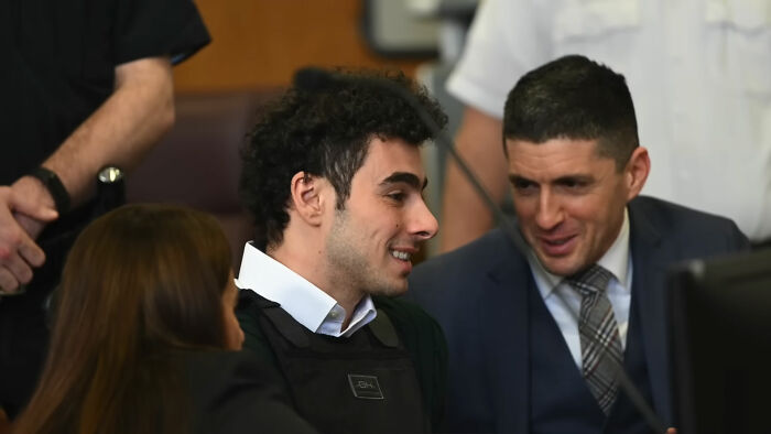 People sitting in a courtroom discussing wild theories enthusiastically.