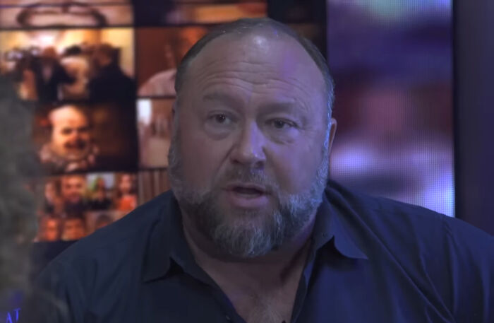 A person in a dark shirt during a discussion, with unprofessional attire images in the background.