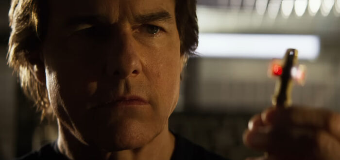 Tom Cruise intensely examining an object, possibly related to a celebrity conspiracy theory.