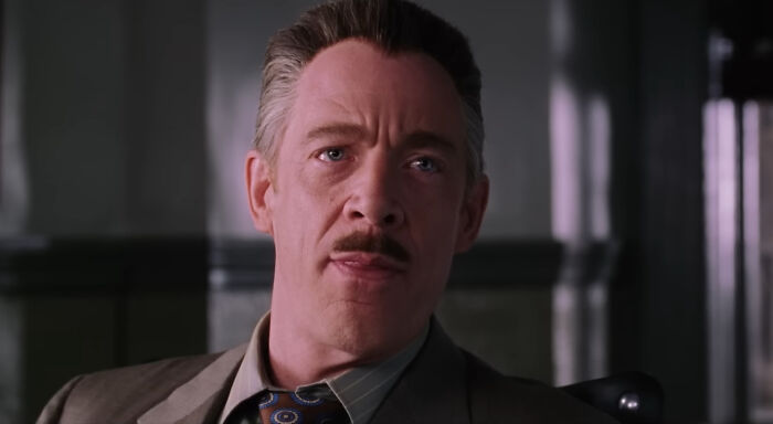 Actor in a serious expression, wearing a suit and tie, representing a memorable character role.