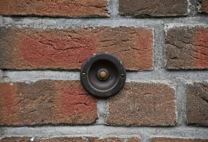 Undercover setting with a vintage doorbell on a brick wall, highlighting an intriguing scene.